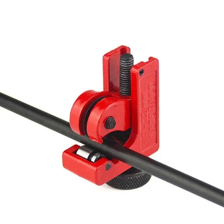 Red pipe cutter holding a black metal pipe on a white background