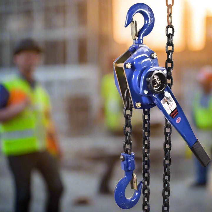 A construction worker in a safety vest stands near a suspended blue chain hoist, showcasing the product in real-world use for heavy lifting and rigging tasks.