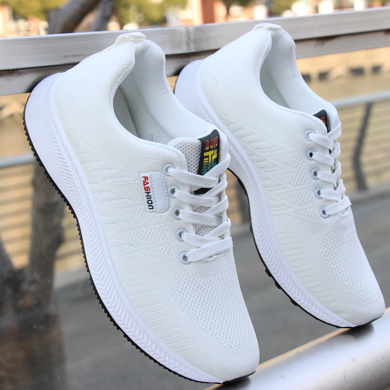 A pair of stylish white sneakers displayed on a balcony railing, showcasing their breathable mesh design and lightweight build.