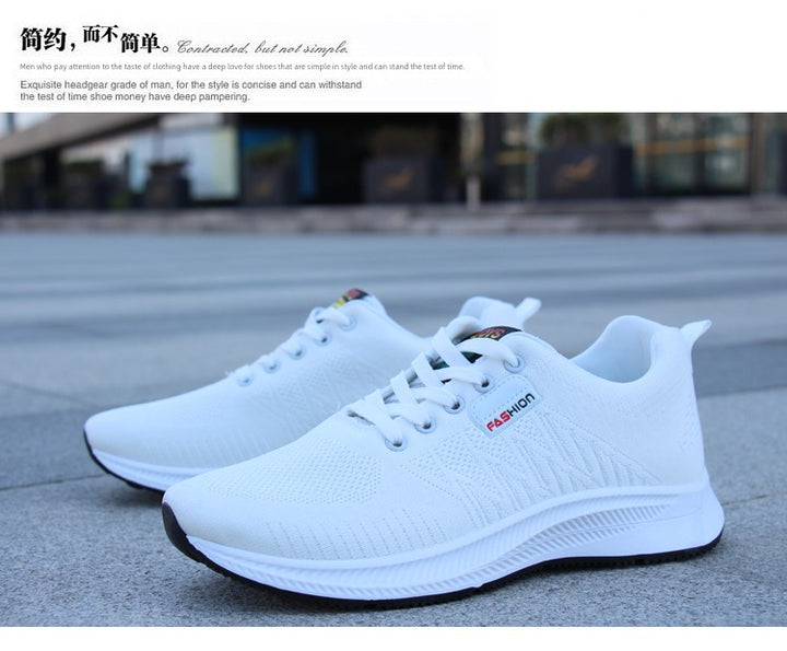 A pair of white sneakers resting on pavement, emphasizing their non-slip sole and fashionable minimalist design.