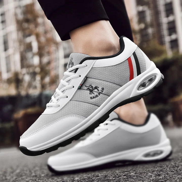 White sneakers featuring a combination of red, grey and black details, adding a sporty touch.