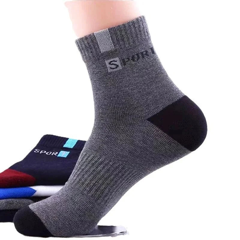 A person wearing dark grey ankle socks with a ribbed cuff for extra support.