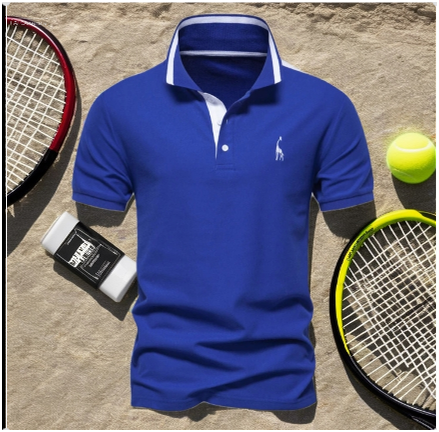 Royal blue polo shirt with white trim laid on a sandy tennis court, surrounded by rackets, tennis balls, and chalk.