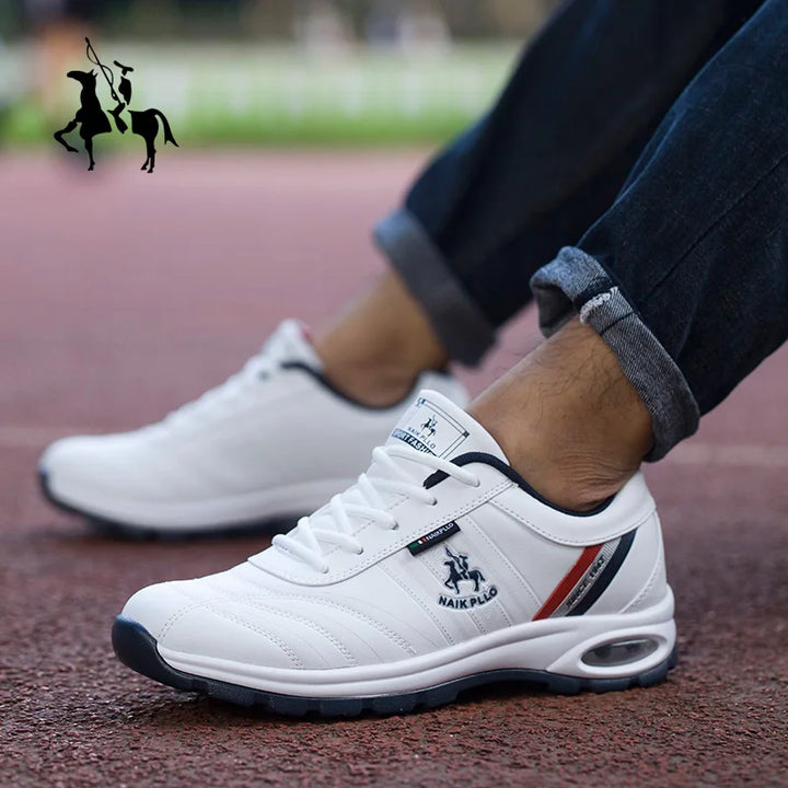 White casual sneakers with black and red detailing, displayed outdoors on pavement.